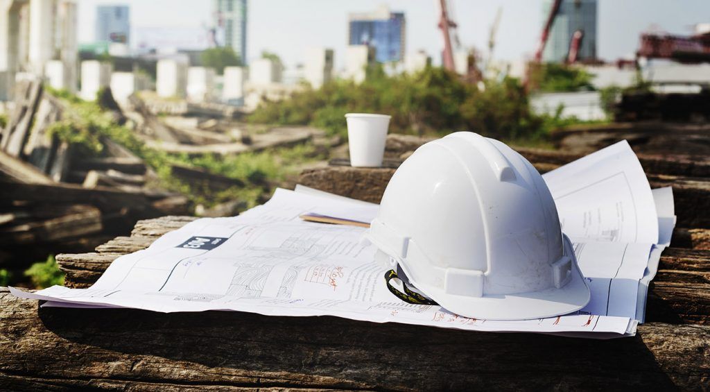 Hard hat and site plans on a construction timber